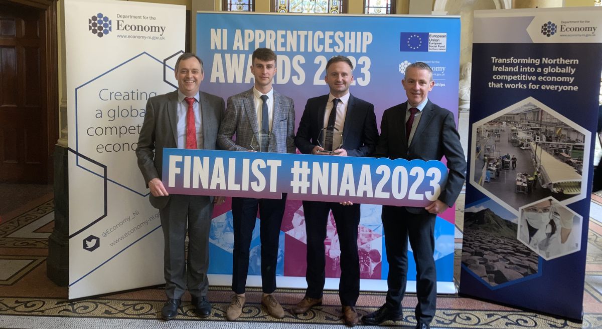 4 people lined up holding a prop board reading Finalists # NIAA2023